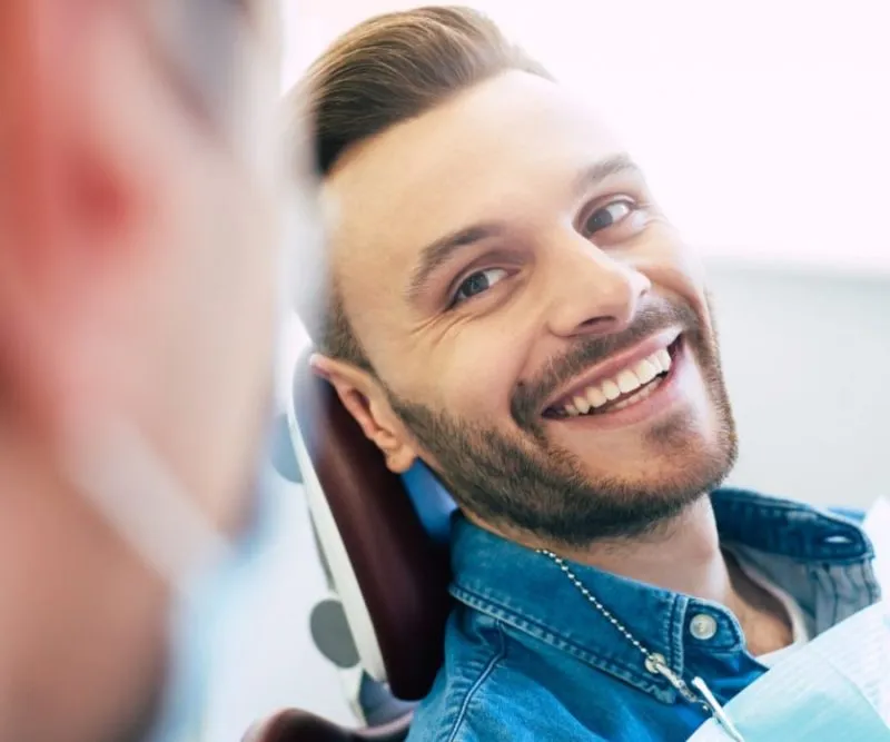 a patient smiling back to a dentist showing healthy teeth